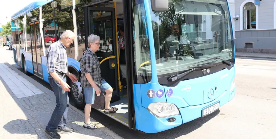 Två pensionärer kliver på bussen