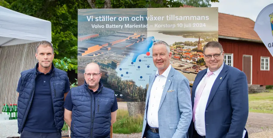 Volvos och kommunens representanter vid en tavla där det står "Vi ställer om och växer tillsammans"